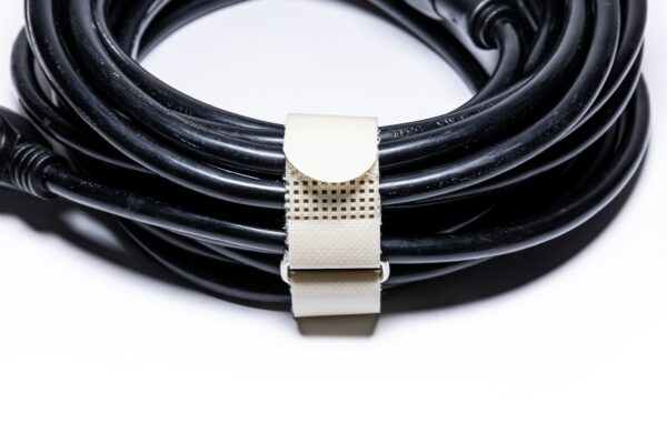 KVNR6806-min - Speedtech International A black cable is neatly coiled and secured with a beige SPEEDWRAP® High Temp Cinch Strap against a white background.